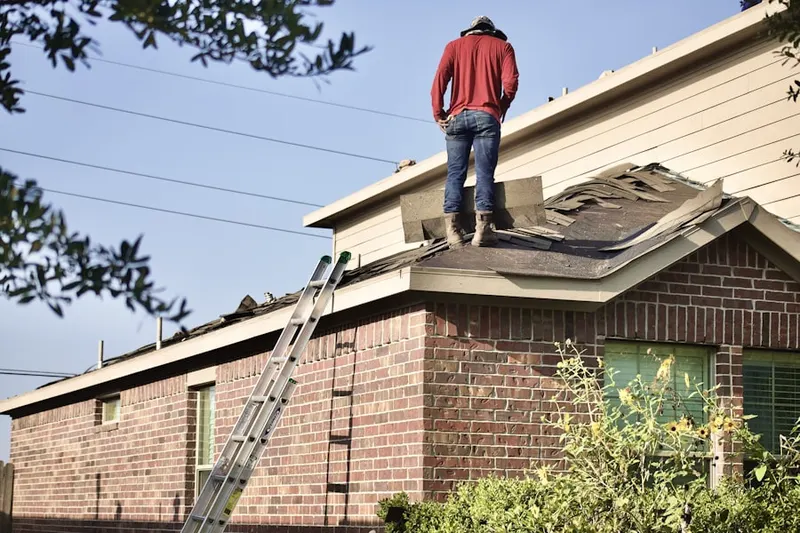 Professional roofer working on a residential roof in East Rochester